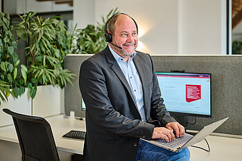 Foto: Managed Services (H4easy) Person mit Headset am Laptop